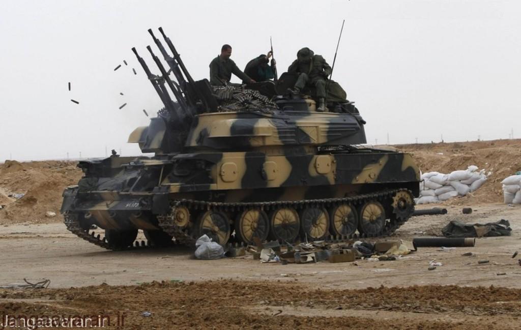 Libyan government soldiers sit on a tank at the west gate of town Ajdabiyah